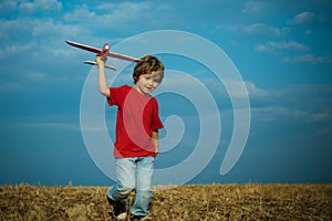 Child boy toddler playing with toy airplane and dreaming future. Active children concept. Concept kids and nature. Happy