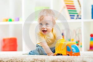 Child boy toddler playing with toy car