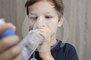 Child boy using medical spray for breath photo