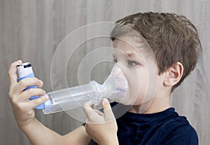 Child boy using medical spray for breath photo