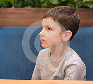 Child boy is waiting for his order in cafe