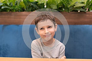 Child boy is waiting for his order in cafe