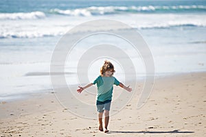 Child boy walk to sea beach, raised hands. Amazed surprised kids emotions.