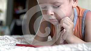 Child boy watch play smartphone on bed at home. distance learning education