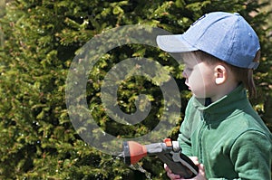 A child, a boy, watering a rubber hose in a garden, a country house, watering