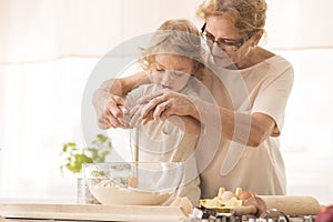 Child breaking the egg into a bowl