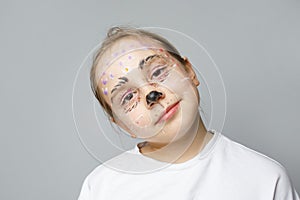 Child with bright paint on face, studio portrait. Face painting