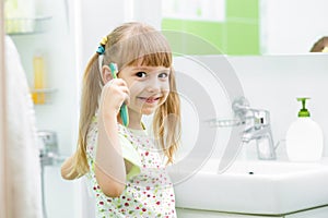 Child brushing teeth in bathroom
