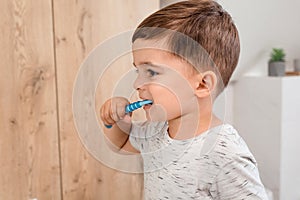 Child brushing teeth. Kids tooth brush and paste. Little funny baby boy brushing his teeth in modern bathroom on sunny