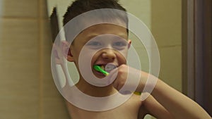 Child brushing teeth looking in mirror