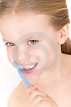 Child brushing teeth with toothpaste - smiling girl