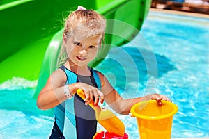 Child with bucket in swimming pool