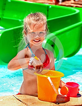 Child with bucket in swimming pool