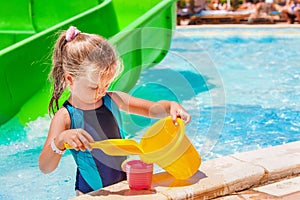 Child with bucket in swimming pool