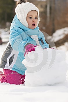 Child building snowman.