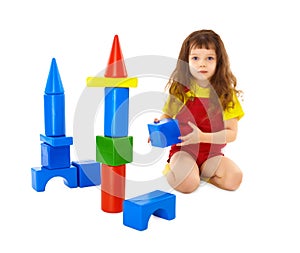Child builds a toy castle on floor