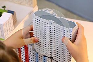A child builds a toy multi-storey house - simulator of the city and urbanization