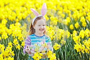 Child with bunny ears on Easter egg hunt