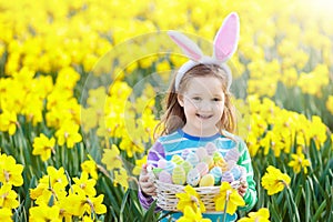 Child with bunny ears on Easter egg hunt