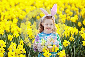 Child with bunny ears on Easter egg hunt