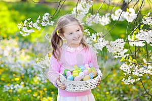 Child with bunny ears on garden Easter egg hunt