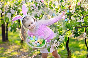 Child with bunny ears on garden Easter egg hunt