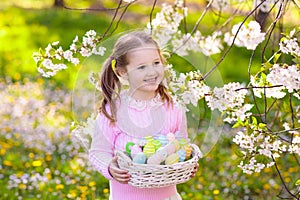 Child with bunny ears on garden Easter egg hunt