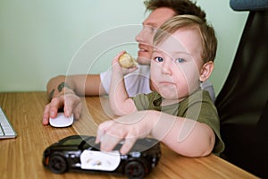 Child is busily using computer, looking in camera
