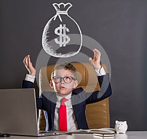 Child businessman with earned money in big bag. Ideas how to earn money. Funny little kid boss sitting in leather