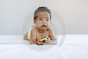 Child Care Concept. Cute African American Baby Lying In Bed With Toy