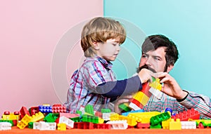 Child care development and upbringing. Father son game. Father and son create constructions. Bearded man and son play photo