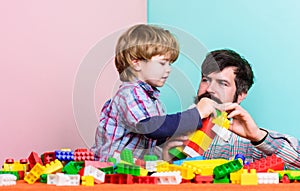 Child care development and upbringing. Father son game. Father and son create constructions. Bearded man and son play