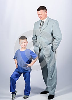 Child care development upbringing. Respectable profession. Man respectable businessman and little kid doctor uniform