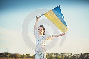 Child carries fluttering blue and yellow flag of Ukraine