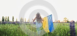 Child carries fluttering blue and yellow flag of Ukraine