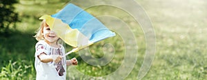 Child carries fluttering blue and yellow flag of Ukraine in field. Ukraine& x27;s Independence Day. Flag Day