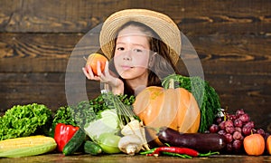 Child celebrate harvesting. Kid farmer with harvest wooden background. Family farm festival concept. Traditional