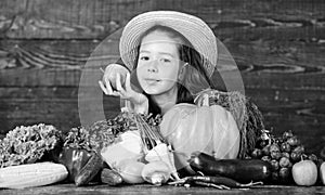 Child celebrate harvesting. Kid farmer with harvest wooden background. Family farm festival concept. Traditional