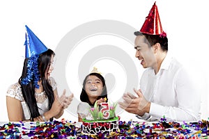 Child celebrates birthday party with her parents