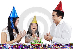Child celebrating a birthday with her parents