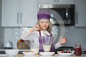 Child chef cooking meal. Chef child cook baking on the kitchen.