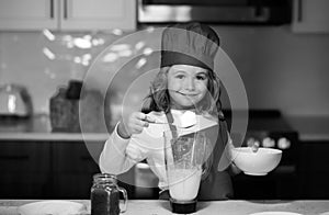 Child chef cooking meal. Child making tasty delicious. little boy in chef hat and an apron cooking in the kitchen.