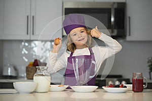 Child chef hold eggs. Cooking child. Kid chef cook is learning how to make a cake in the home kitchen. Kid boy in chef