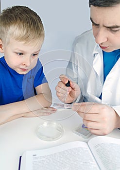 Child chemist. Teacher shows a visual experiment. A science mentor teaches an experimental approach. Microscope, petri dish,