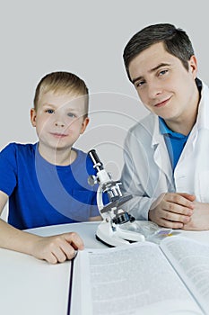 Child chemist. Teacher shows a visual experiment. A science mentor teaches an experimental approach. Microscope, petri dish,