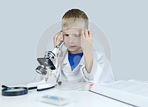 Child chemist. Teacher shows a visual experiment. A science mentor teaches an experimental approach. Microscope, petri dish,