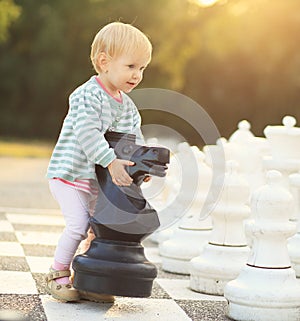 Child with chess figures outdoor