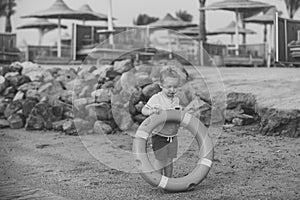 Child Childhood Children Happiness Concept. Boy small kid holding orange ring saver at coast