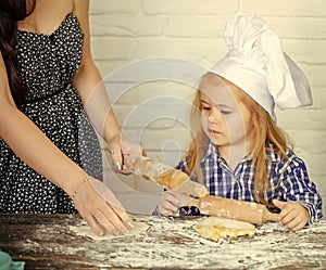 Child Childhood Children Happiness Concept. Child with serious face learning to roll dough