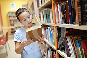 Child choosing book in library